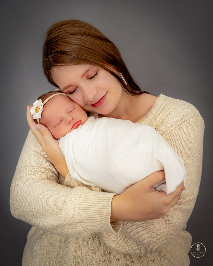 Mother caresses her Newborn in a portrait by Brisson Imagery