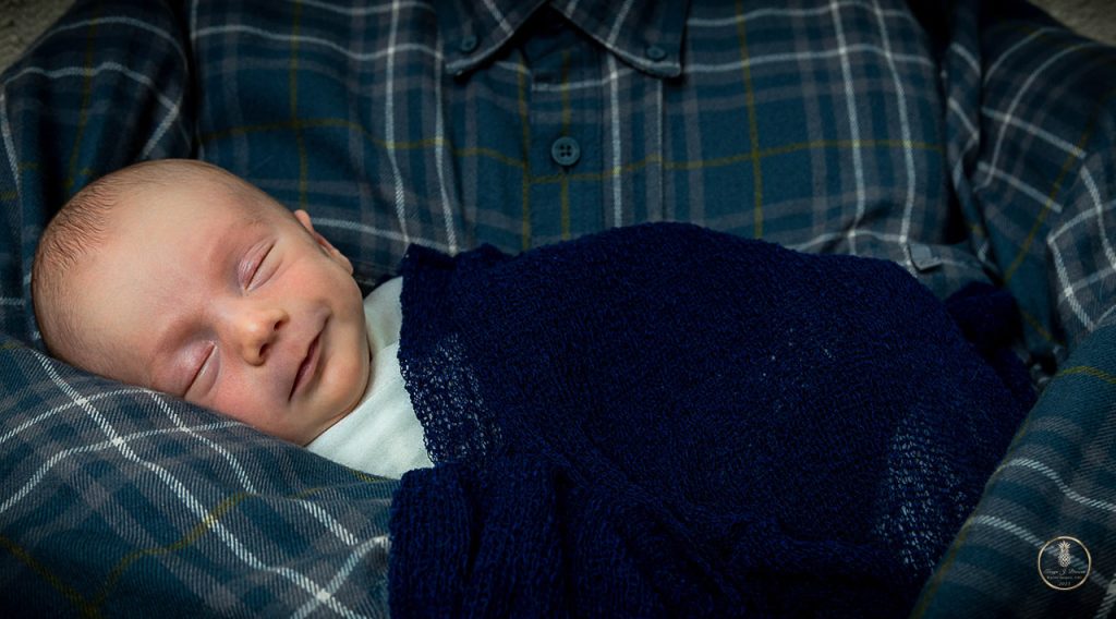 Newborn baby boy poses in his deceased grandfathers shirt