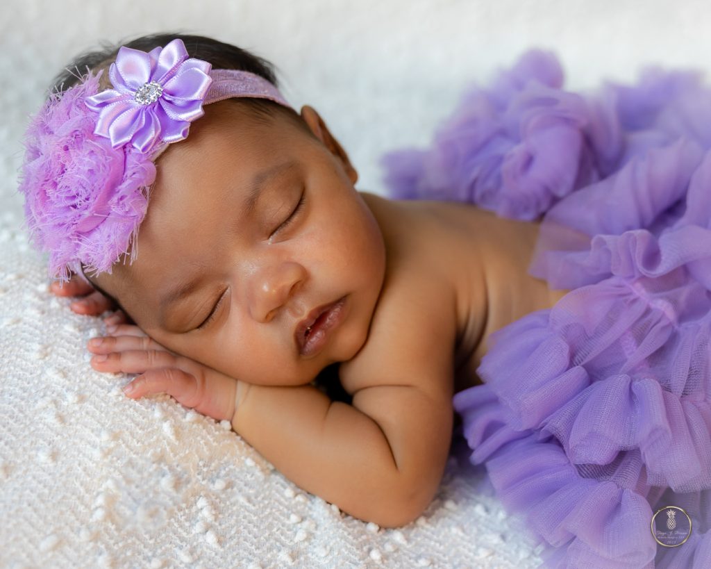 Newborn Baby girl in a purple tut with a matching headband portrait by Brisson Imagery