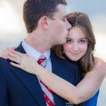 Engagement portrait by Brisson Imagery. Citadel Cadet kisses fiance on the temple whie she hugs his neck smiling at the camera. her engagement ring prominent to the camera