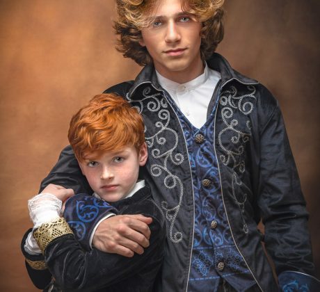 Two bothers pose wearing Hamilton Costumes, older brother has younger brother in a loving headlock. Portrait by Brisson Imagery.