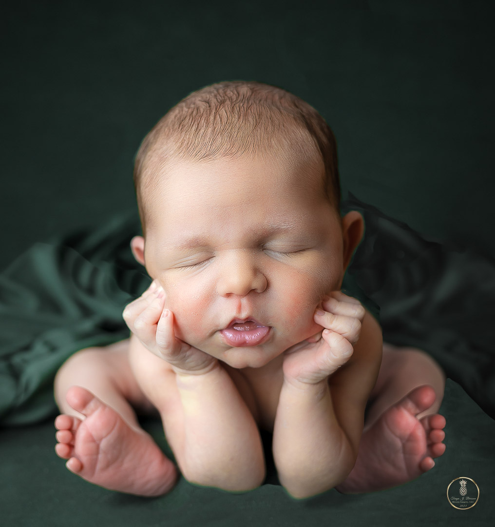 Newborn Baby posed in the Froggie pose. Portrait by Brisson Imagery