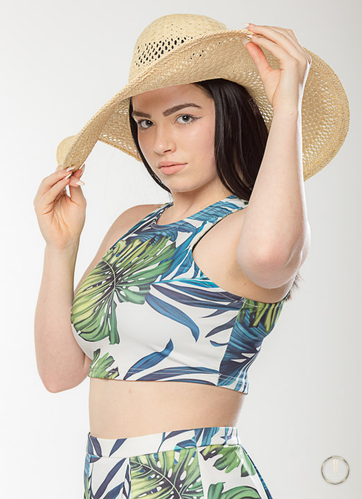 teen girl poses in studio with sun hat