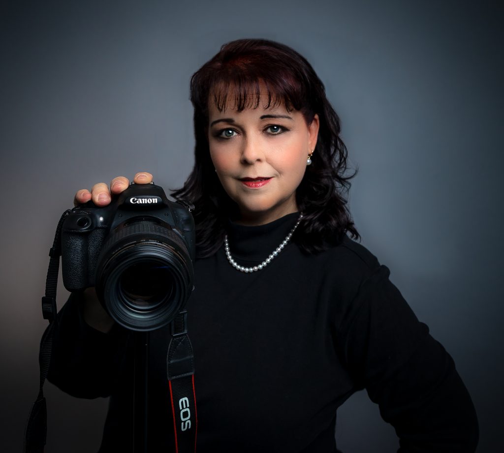 Tonya Brisson posing with a camera on a tripod