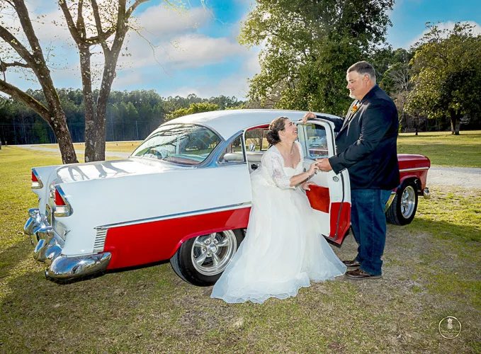 Charleston Elopment Photographer image of a groom helping his bride get out of an antique car 