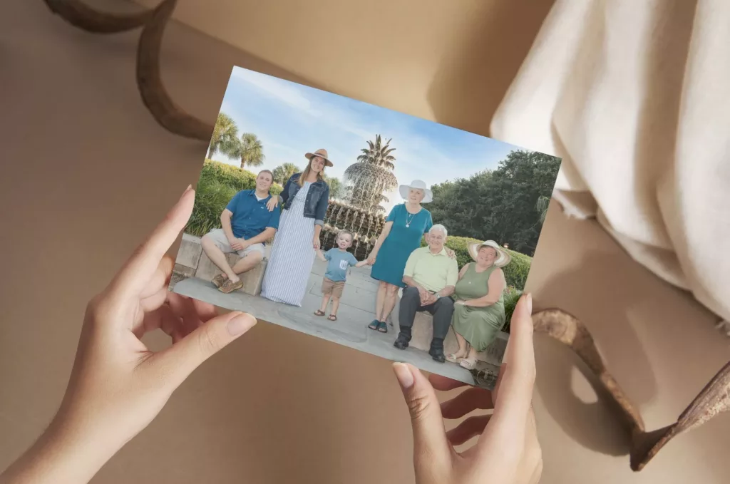 Picture of a woman holding a card with a family portrait on the front